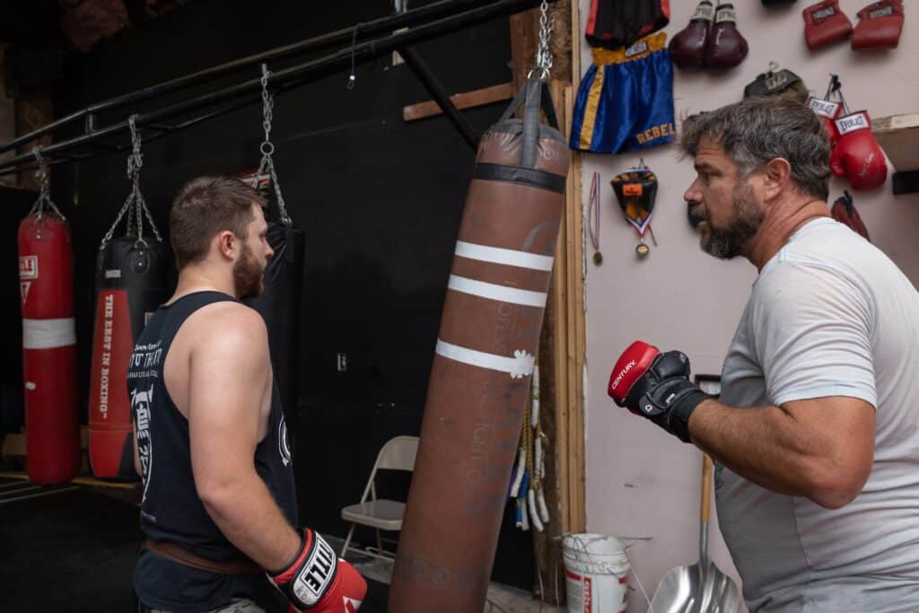 homeland heroes student and instructor with punching bag during boxing and mma class