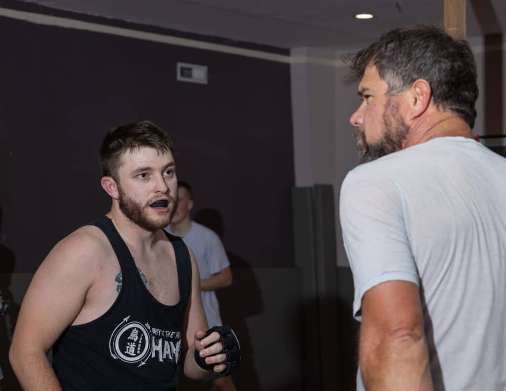 instructor and student at homeland heroes talking during mma class