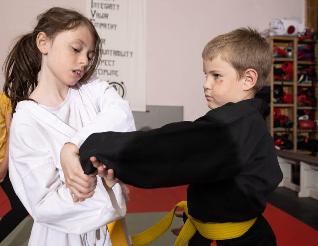 two young homeland heroes students practicing proper holds for kids jujutsu class