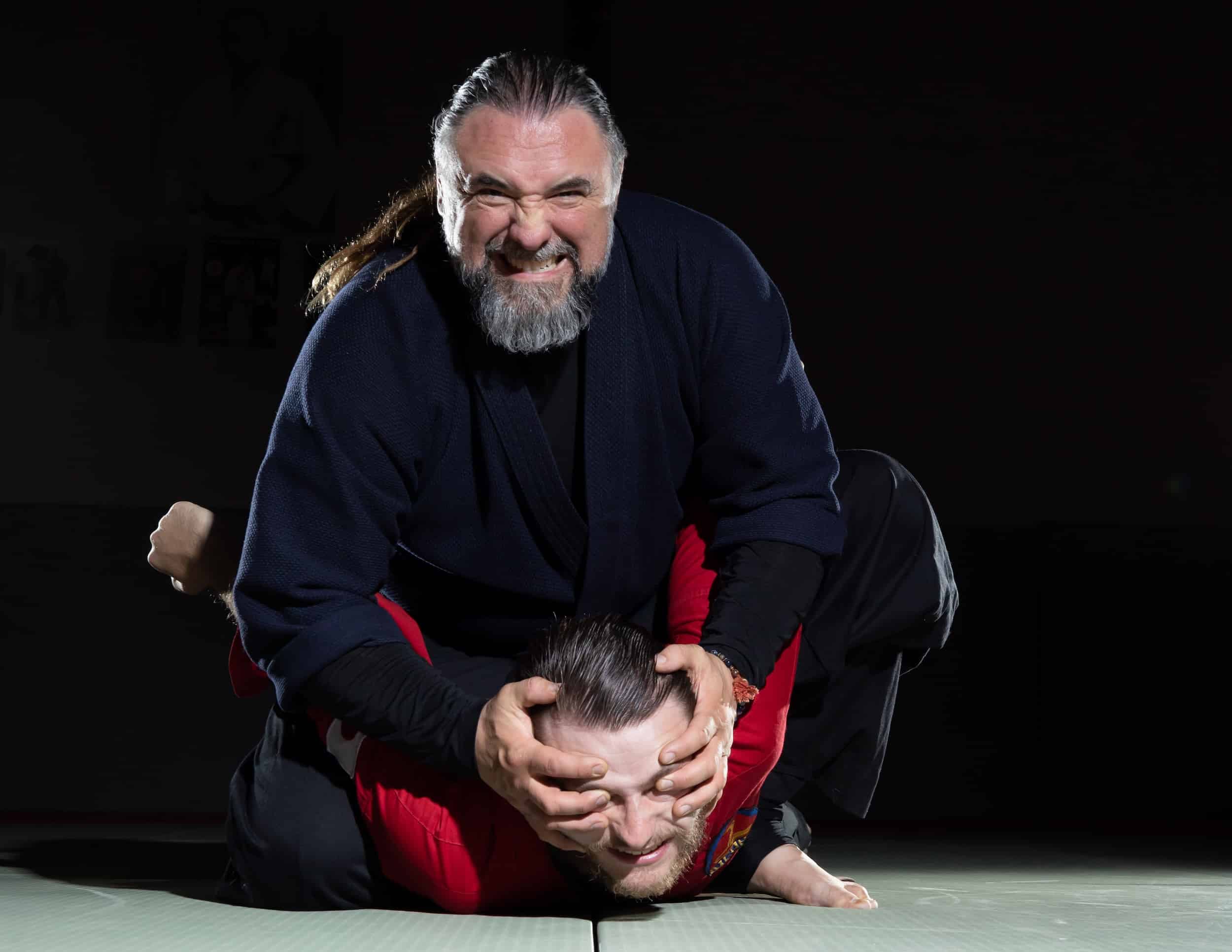 homeland heroes instructor sitting on student during self-defense demonstration